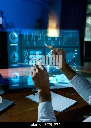 Engineer adjusting futuristic logistics control panel with holographic interface. Collage Stock Photo