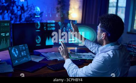 Man in smart glasses interacts with futuristic data dashboards and AI analytics interface. Collage Stock Photo