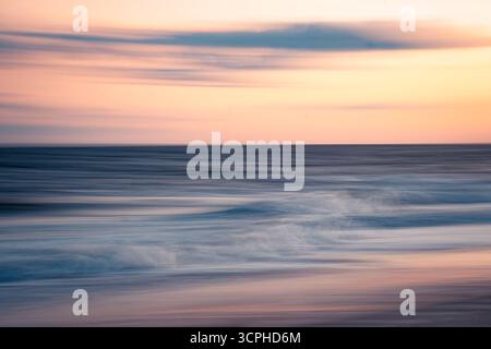 Long Exposure abstract seascape at beach at sunset with flowing ocean sea water movement and colorful sky Stock Photo