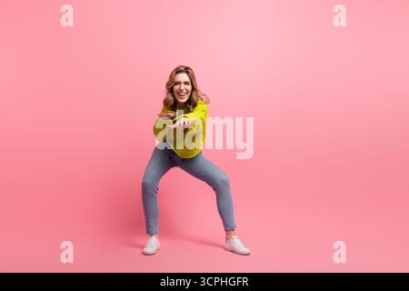 Adorable cheerful woman in trendy casual outfit posing with joy and smiling over vibrant pink background Stock Photo