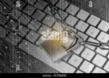 Padlock and chain on computer keyboard, closeup. Circuit board pattern and binary code. Cyber security Stock Photo