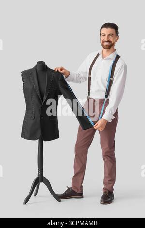 Male tailor measuring jacket on white background Stock Photo