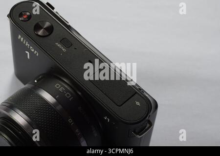 Closeup of black nikon 1 j1 interchangeable lens camera on isolated background. Nikon dlsr camera with 1 inch sensor. Stock Photo