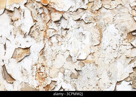 Peeling paint on industrial wall. Old grunge surface with cracked plaster. Vintage texture for construction and architecture. Stock Photo