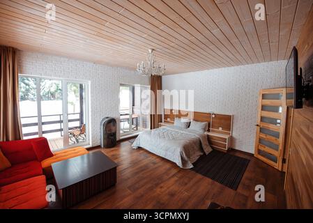 Cozy modern bedroom with wooden accents and large windows Stock Photo