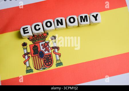 Economy on stacked wooden cubes with Spanish flag on the table. Business and finance concept Stock Photo