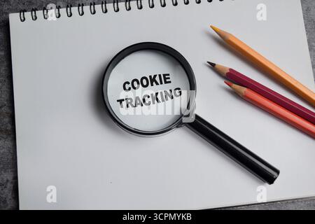 Concept of cookie tracking write on book with magnifying glass isolated on Wooden Table. Stock Photo