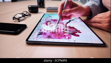 Creative Designer Editing Digital Artwork On Tablet At Desk Stock Photo
