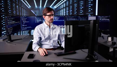 Elderly Male Cyber Security Technician Monitors Server Room Operations Stock Photo