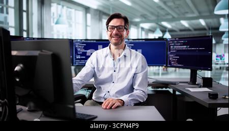 Elderly Programmer Smiling While Writing Code For Web Development Project. Stock Photo