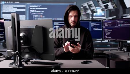 Senior Man Using Balaclava To Hack Mobile Phone For Fraud. Stock Photo