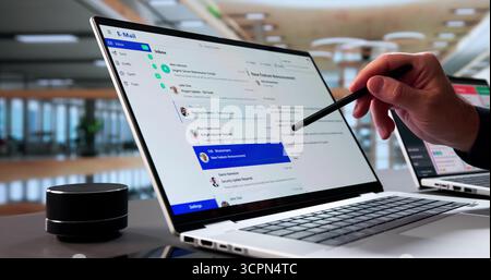 Senior Businessman Multitasking On Laptop, Checking Emails At Office Desk. Stock Photo