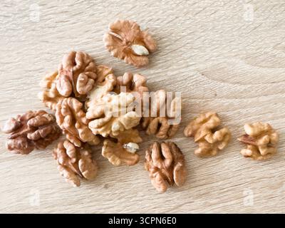 Walnuts kernels on dark desk with color background, Whole walnut in wood vintage bowl. Stock Photo