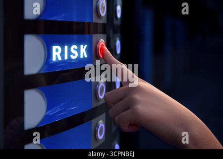 Woman pressing button near word Risk on vending machine, closeup Stock Photo