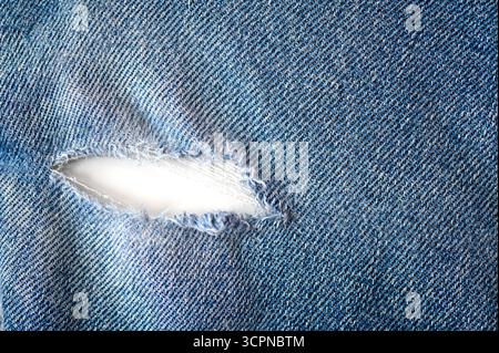 Top view of damaged, torn jeans with hole as texture or background, space for text Stock Photo