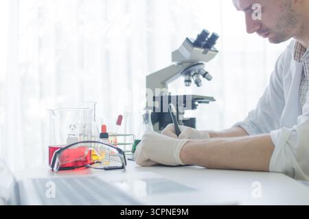 Medical or scientific researcher or man doctor looking at a test tube of clear solution in a laboratory Stock Photo