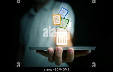Futuristic digital recycle bin on tablet screen with documents dropping, representing data deletion, secure file storage, information management, and Stock Photo