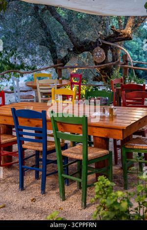 brightly painted primary-coloured chairs and tables at a bohemian or shabby chic style Greek taverna on the island of Zante or Zakynthos in Greece Stock Photo