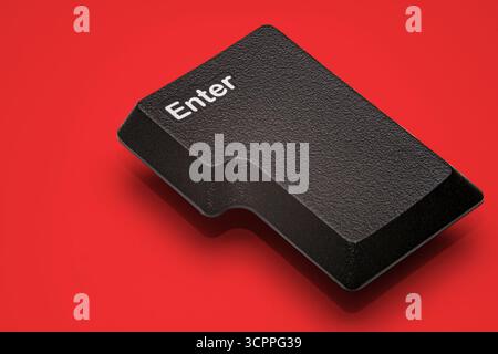 Close-up of a black “Enter” key on the keyboard. Prominently displayed on a vibrant red background. The texture of the key has aesthetic qualities. Stock Photo