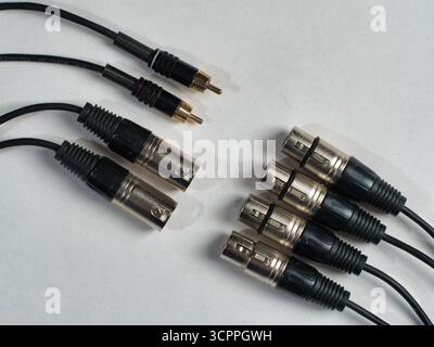 Audio connectors and sound cables close up - Different audio cables with XLR and RCA connectors on white background, professional music equipment for Stock Photo
