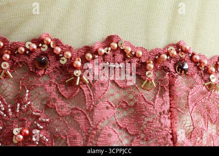 Textured and patterned background. Red brocade. Floral embroidery adorned with pearl beads. Stock Photo