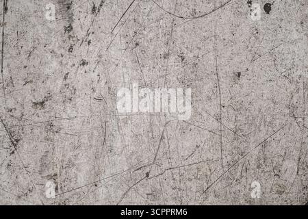 Scratched and weathered grunge surface. The texture has a rough, worn appearance with a mix of light and dark tones. Stock Photo
