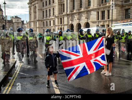 LONDON, UK. 13th August 2025.  Mother and Son in front of a line of Met Police officers at the Unite the Kingdom march. Photo Credit: Ian Humphreys Stock Photo