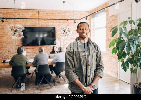 Portrait of confident male business professional standing in office Stock Photo