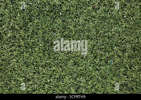 Close-up and top view of green artificial grass on multiple use sports field. Stock Photo