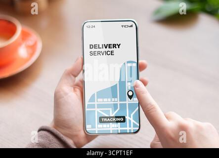 Woman using smartphone with opened delivery service tracking app, checking order status Stock Photo