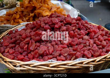 Dehydrated dried tropical fruits in pieces in baskets, mango, berries, citrus on weekly food market in Toulouse, France Stock Photo