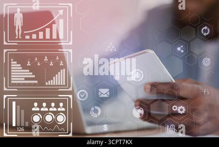 Unrecognizable black HR manager using smartphone and working on laptop Stock Photo