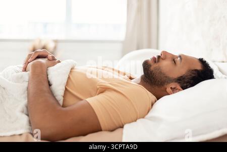 Arabic Young Man Sleeping Lying On Back Resting In Bedroom Stock Photo