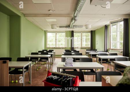 Empty classroom with desks and chairs in junior high school building Stock Photo