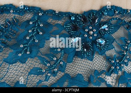 Textured and patterned background. Blue brocade. Floral embroidery adorned with pearl beads. Stock Photo