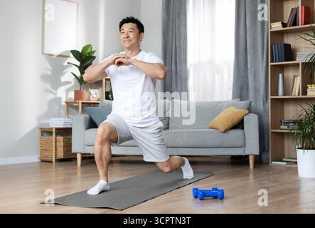 Athletic asian man training alone at home Stock Photo