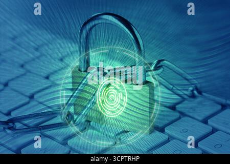 Padlock with digital fingerprint scan and chain on laptop, toned in blue. Cyber security Stock Photo