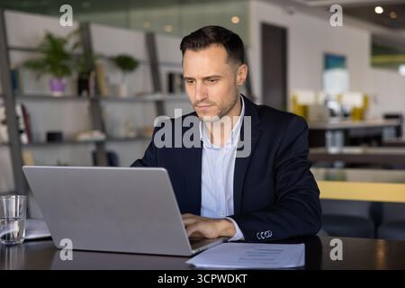 Focused businessman in suit working on his laptop Stock Photo