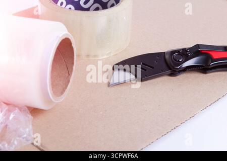 Packaging material. Stretch film and cardboard packaging on a white background. Packing the goods before shipping.. Stock Photo