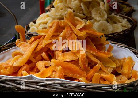 Dehydrated dried tropical fruits in pieces in baskets, mango, berries, citrus on weekly food market in Toulouse, France Stock Photo