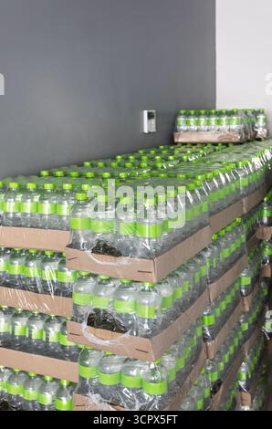 Water bottles, pack, packed in plastic wrap, stored in a shop for sale, green caps Stock Photo