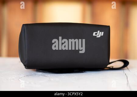 DJI Branded Protective Carrying Case with Shoulder Strap on Wooden Table with Blurred Background Stock Photo