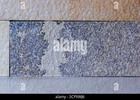 A close-up shows various rectangular stone tiles with different colors and textures. Dominant colors are tans, grays, and browns. Stock Photo