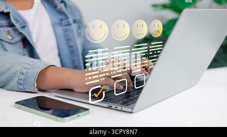 Customer feedback survey concept with satisfaction rating icons on laptop. Online review, UX, user experience, business evaluation, and digital rating Stock Photo