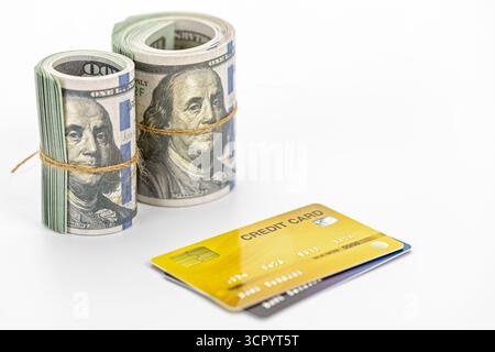 A rolled cash and credit card on white background, financial concept showing money and payment card conveying success and transaction confidence Stock Photo