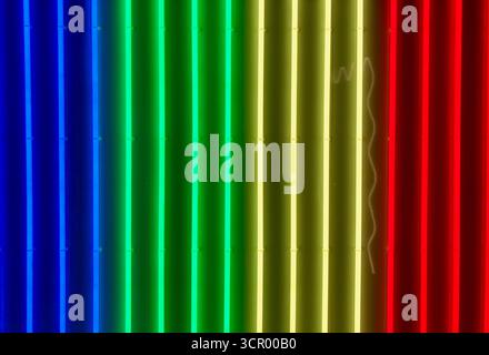 Abstract background of vertical neon light tubes in blue, green, yellow and red, forming a vibrant, colorful pattern with a modern aesthetic. Stock Photo