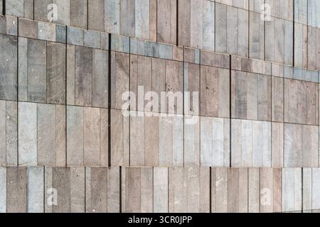 Minimalist stone wall with rectangular tiles in natural tones and subtle geometric texture pattern Stock Photo