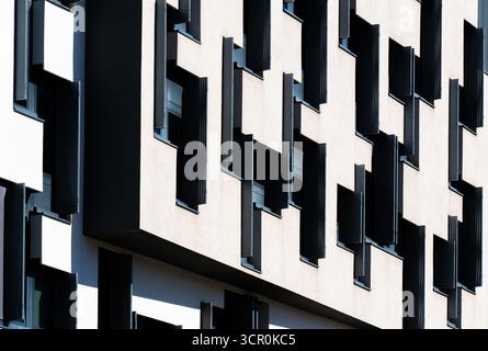 Modern office building with geometric black and white facade featuring irregular window pattern and strong contrast Stock Photo
