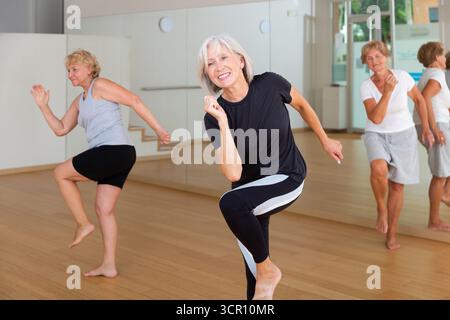 Active mature woman learning dynamic dances in choreography class Stock Photo