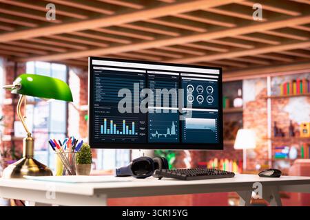 Financial application UI on PC screen in modern home office showing revenue and expenses. Accounting annual review on computer monitor in apartment showing company profits made Stock Photo